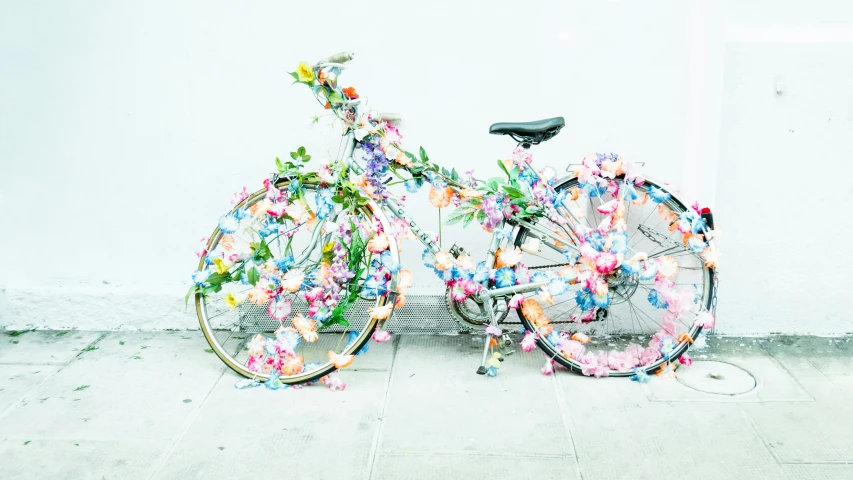 two bicycles are covered with flowers, sitting on the sidewalk