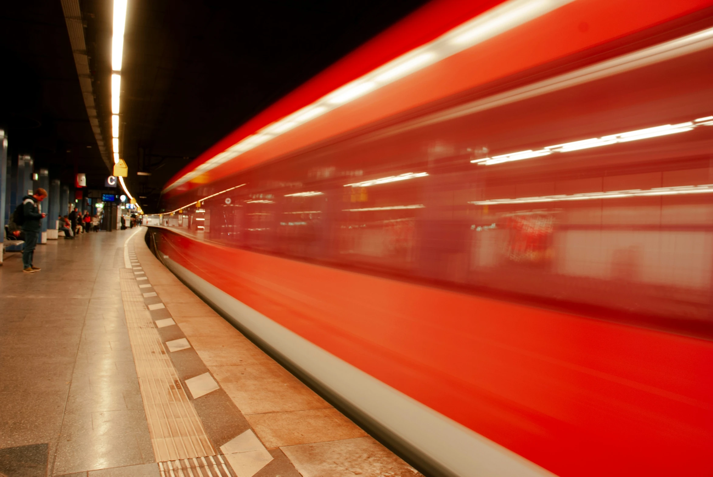 people walking around in front of a long train