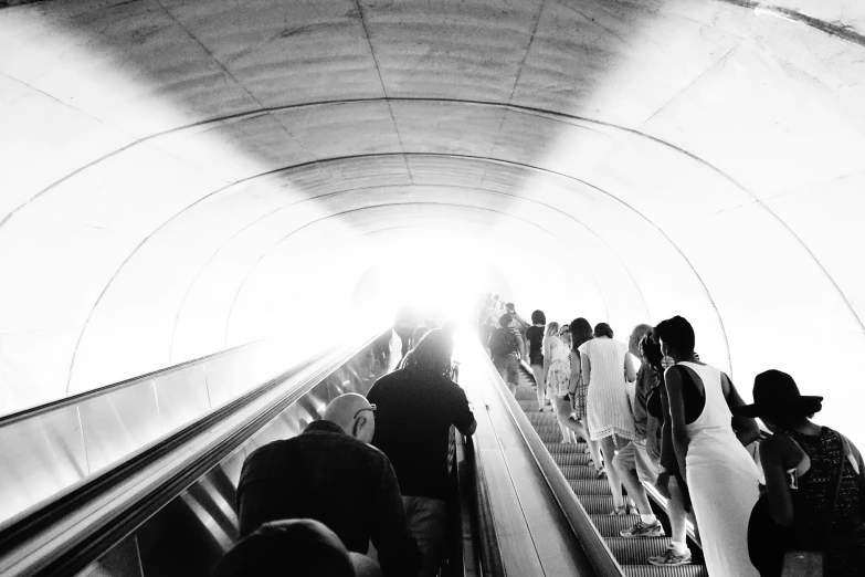 a group of people on an escalator going up the ramp