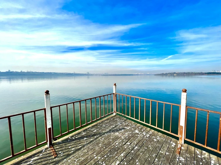 a deck near the water with railings on the sides