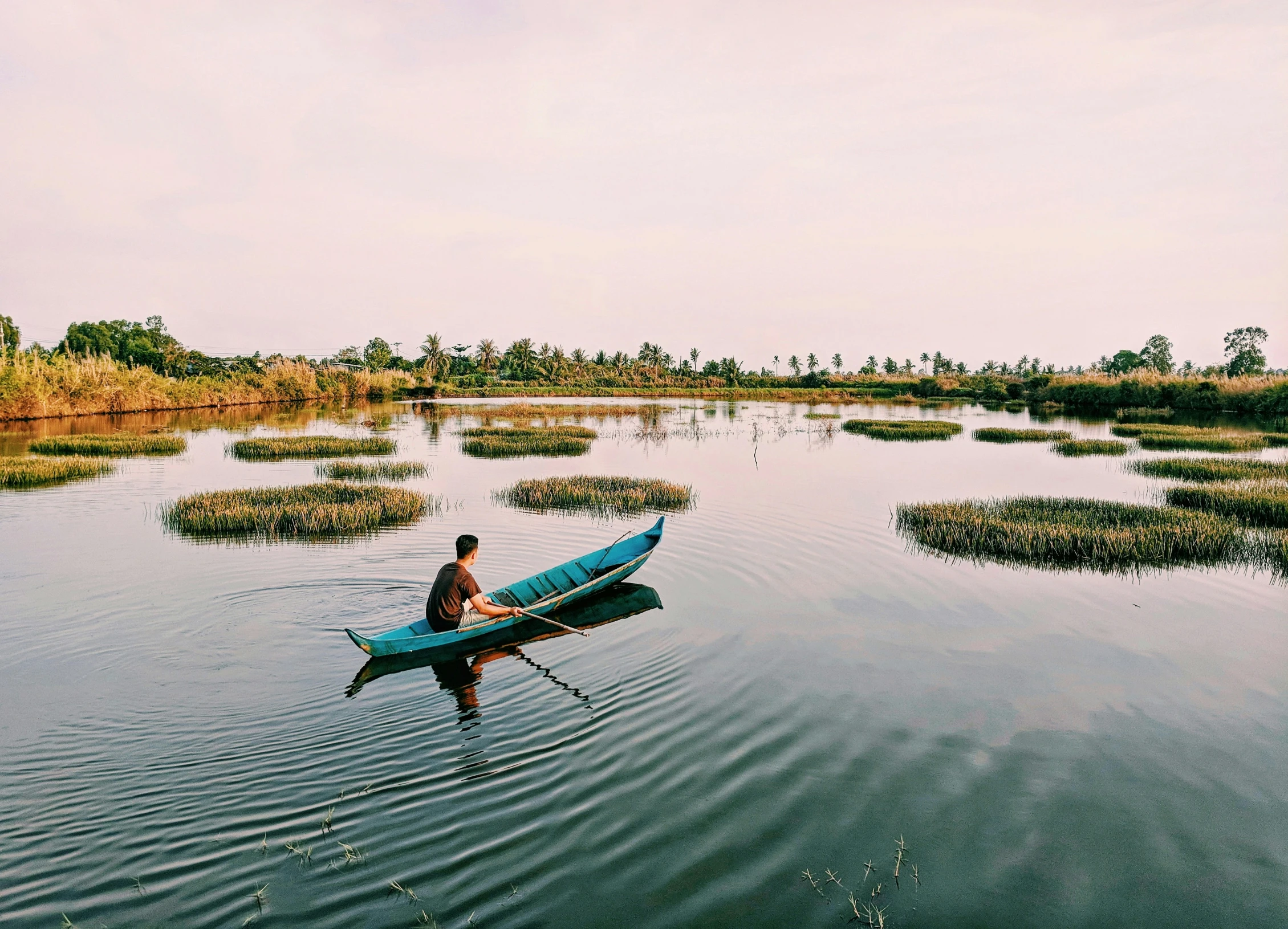 a man riding in a canoe on top of a lake