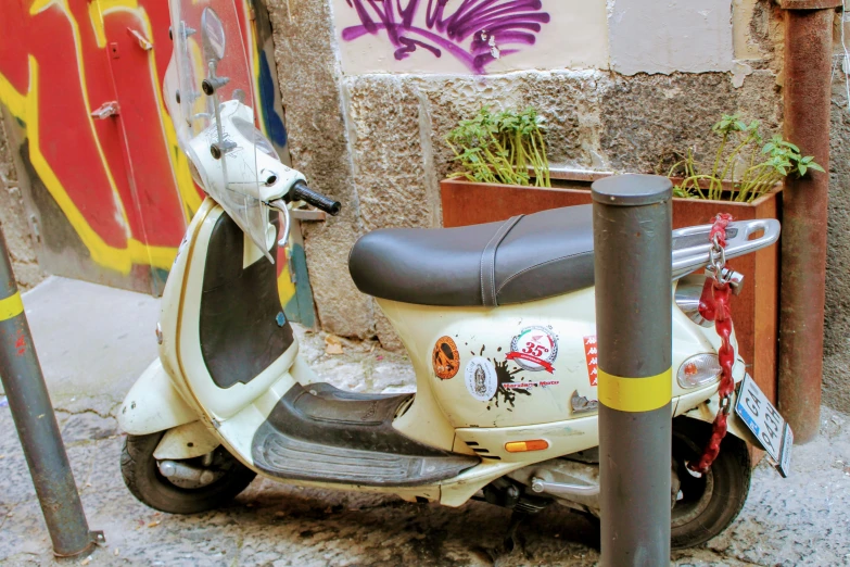 a scooter parked beside a wall on the side of a road