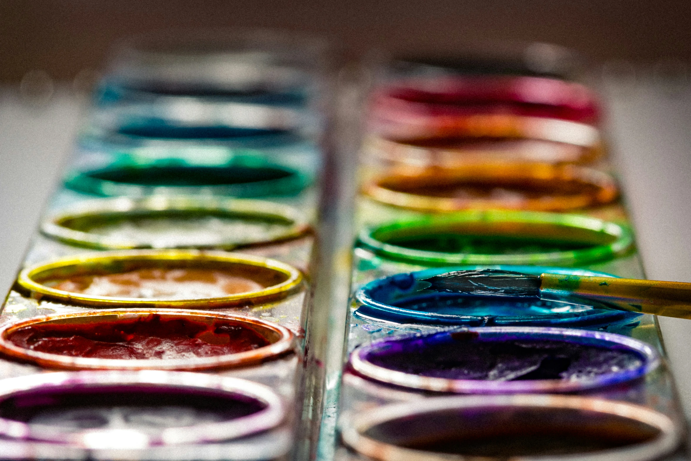 a close up of a row of different colored pens