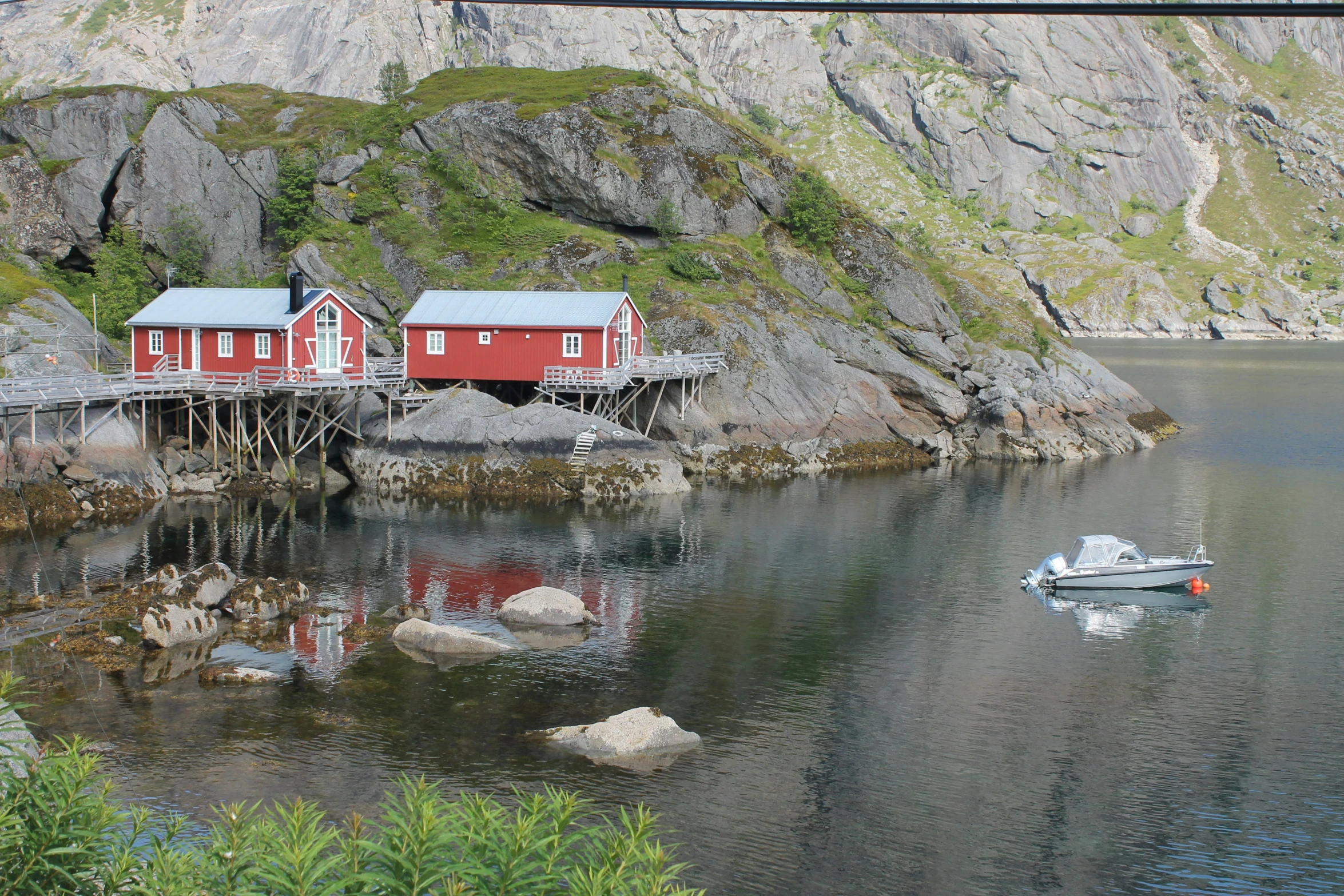 the house is red with a boat next to it