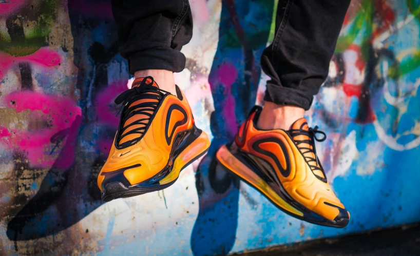 man standing against the wall with colorful paint on his feet