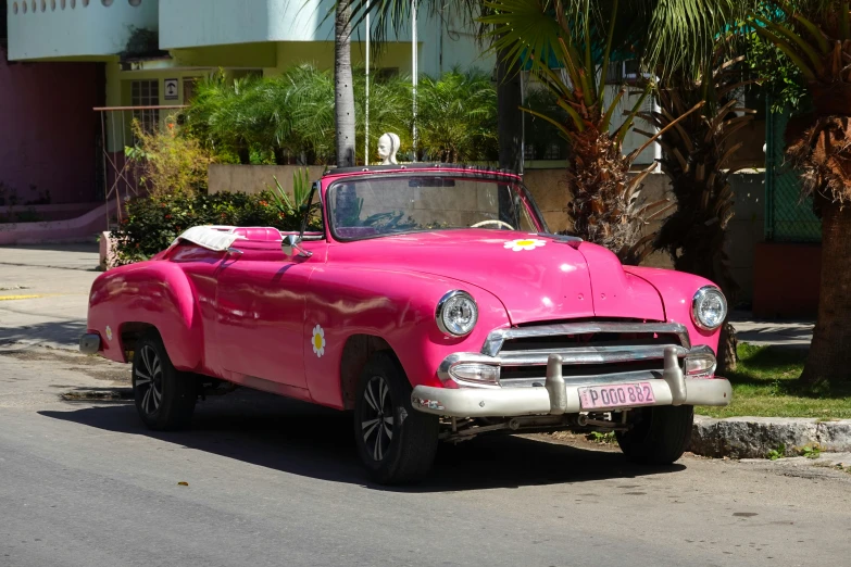 an older classic convertible car is painted pink