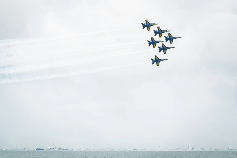 four airplanes making a circle in the sky above water