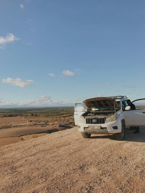 two trucks sitting in the desert with their hood open