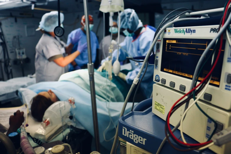 a group of doctors and nurses standing around a patient