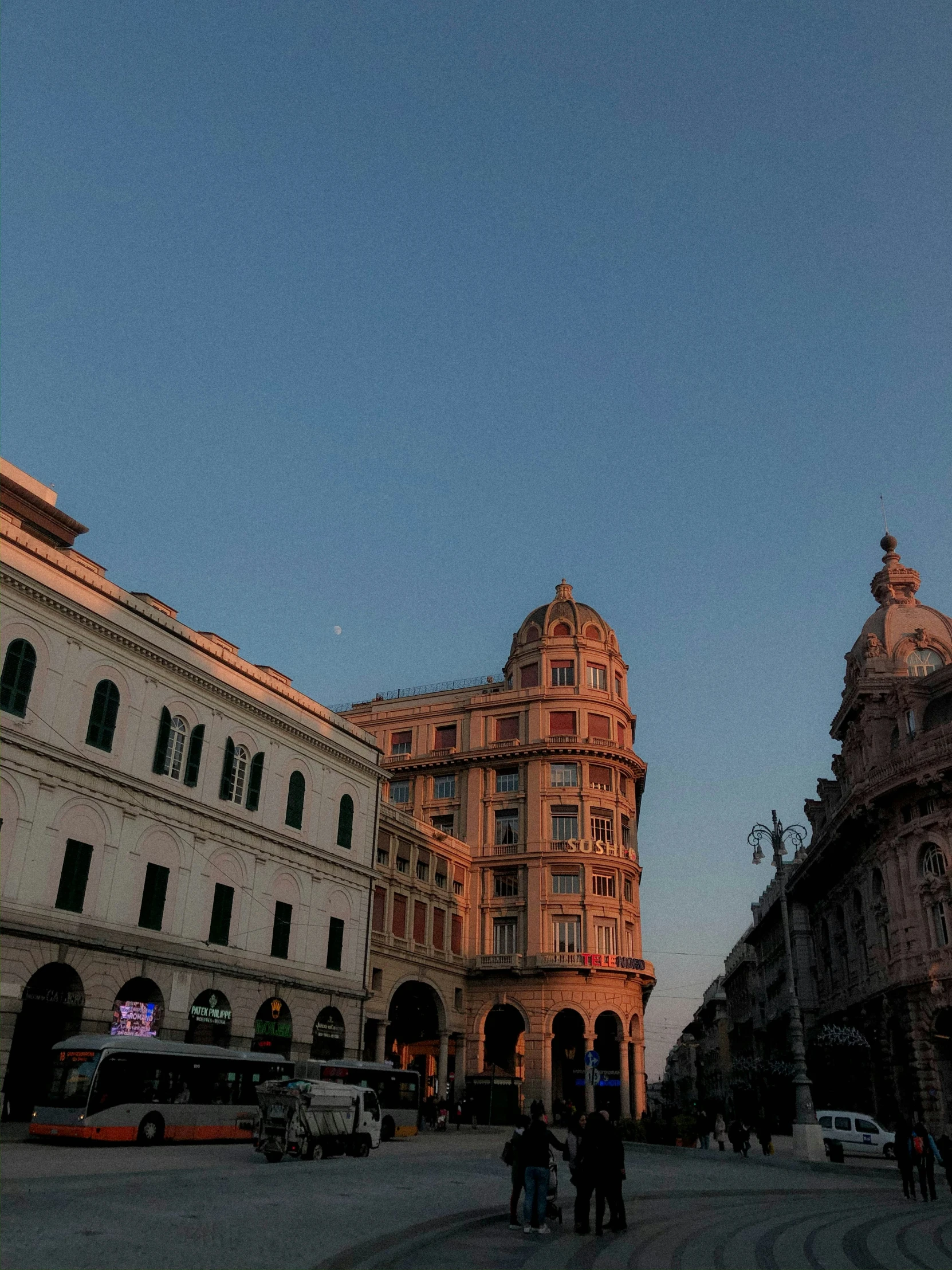 the sun is setting on the corner of this street