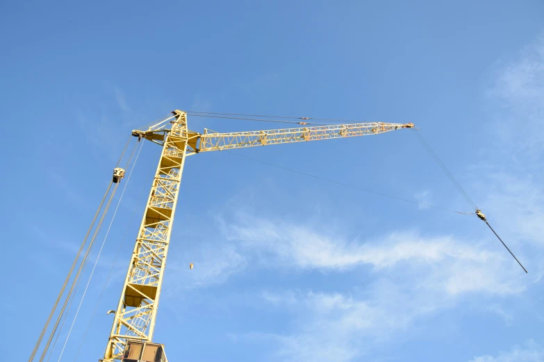 two cranes are high on the blue sky