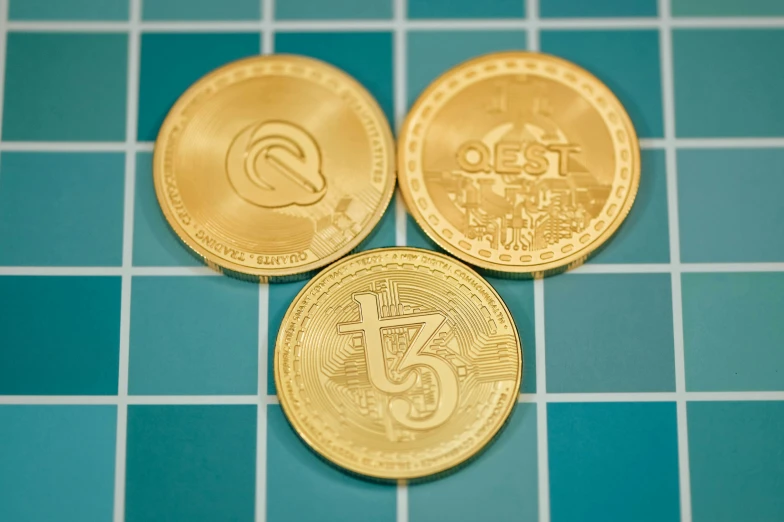 three gold coins are shown laying on a table