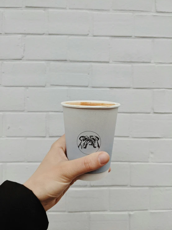 a person's hand holding an espresso drink