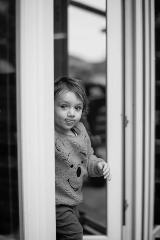 a little girl is standing in the window