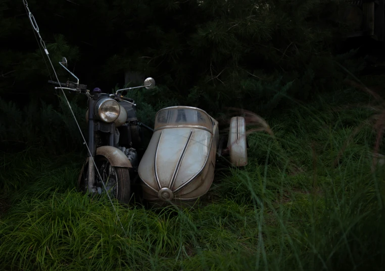 an old motorcycle sitting in a grassy field