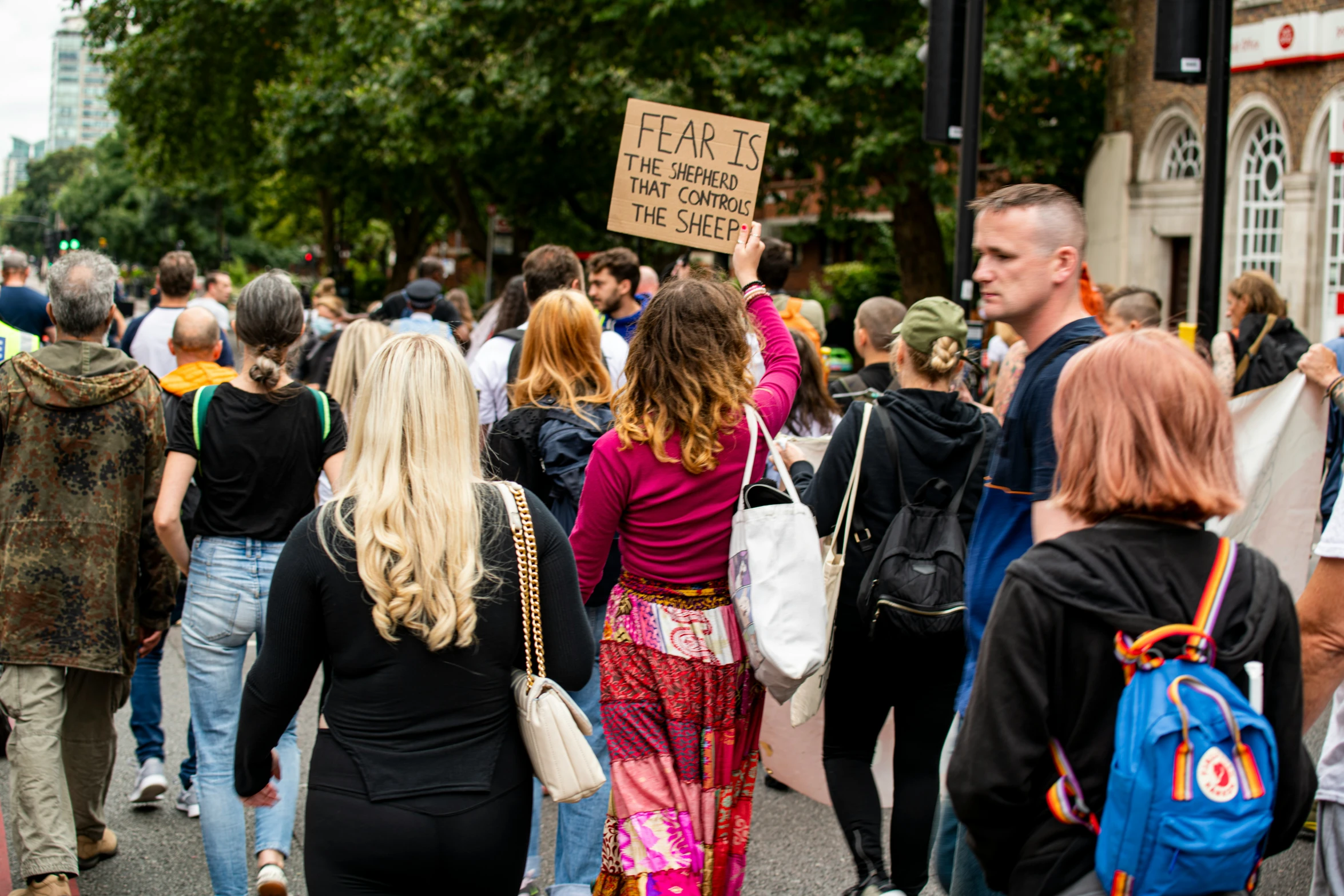 people marching in the street carrying signs and backpacks