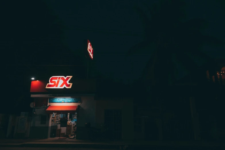 sixxt signs lit up at night in a dark area