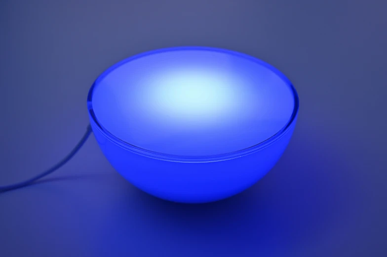 a blue light reflecting off the surface of a round object