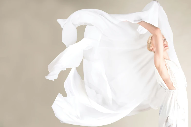a woman is shown pulling up her white fabric