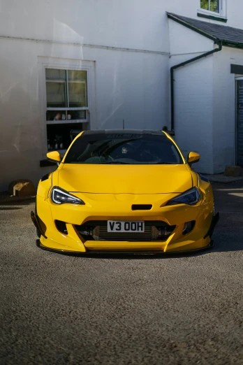 the yellow sports car is parked in front of a building
