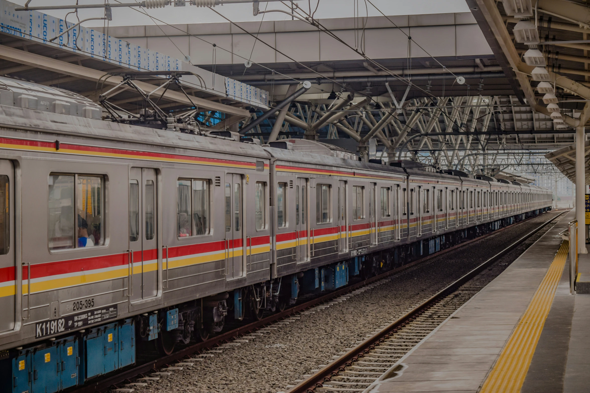 a silver train pulling into the station for passengers