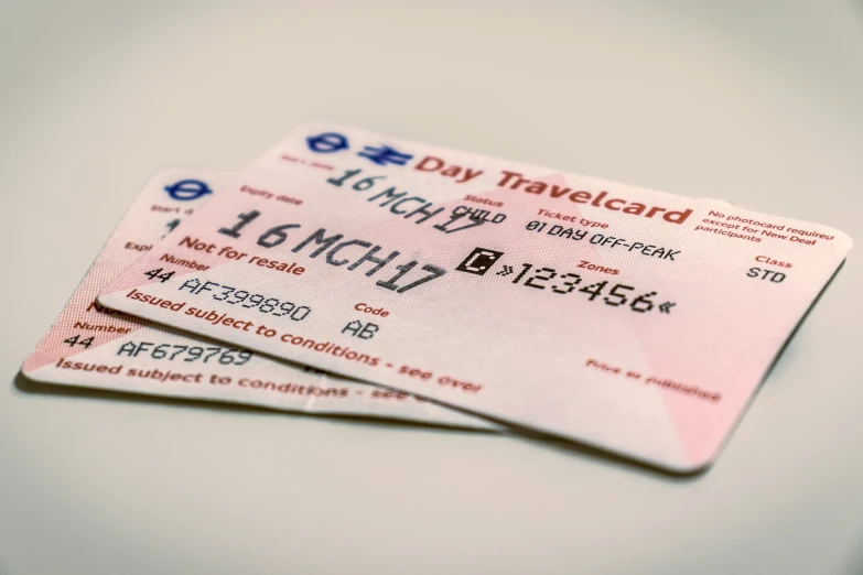 two pink luggage tickets on a white table