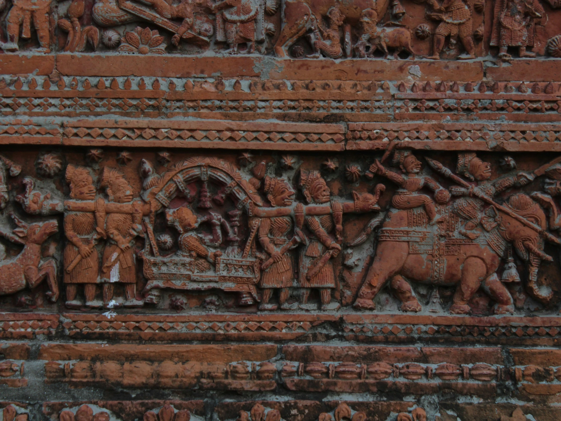 an ancient architectural wall with a painting of indian men fighting