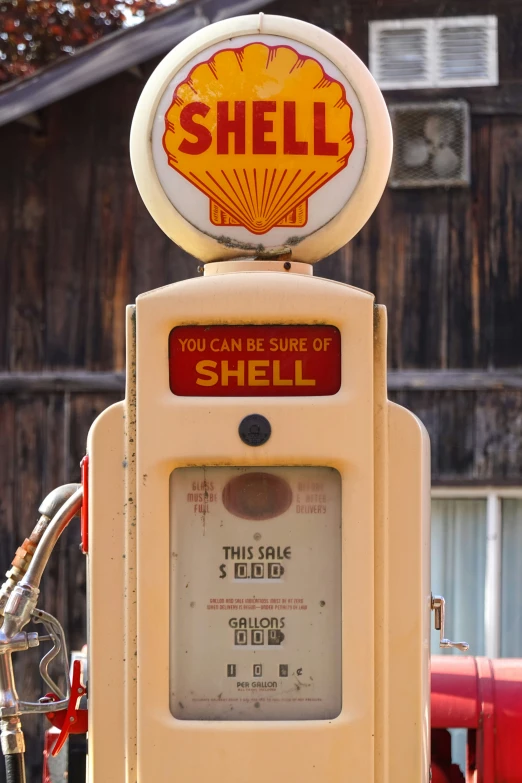 an old shell shell gas pump sitting on top of a sidewalk