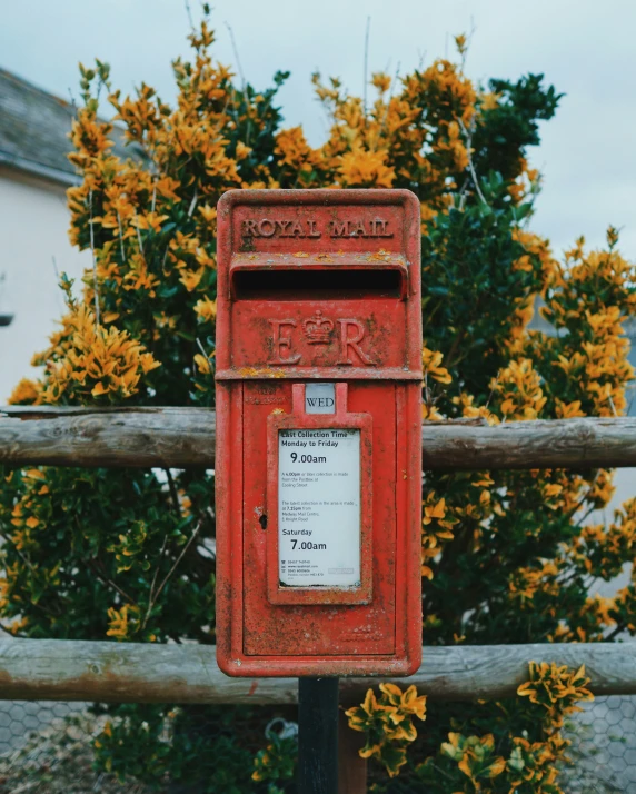 a mail box is pictured sitting on a wooden post