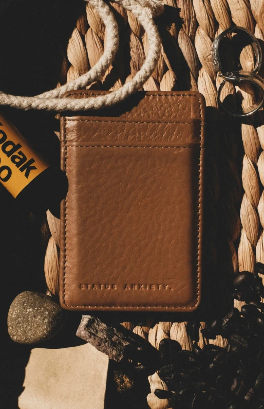 a brown wallet sitting on top of a pile of ropes