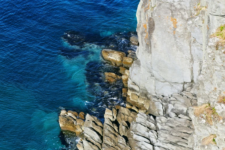 a cliff face that has water crashing in and out of it