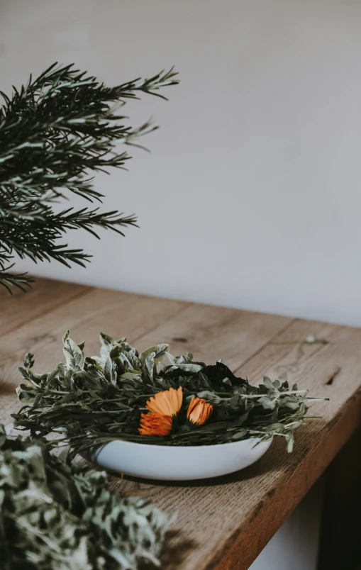 a bowl sitting on a table with some plants