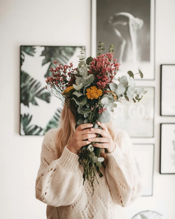 a woman holding flowers up to her face