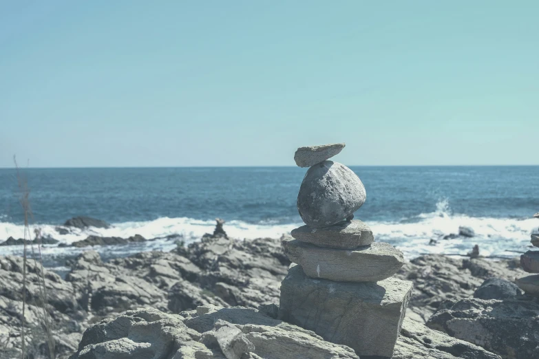 stacked rocks with rocks on it near the water