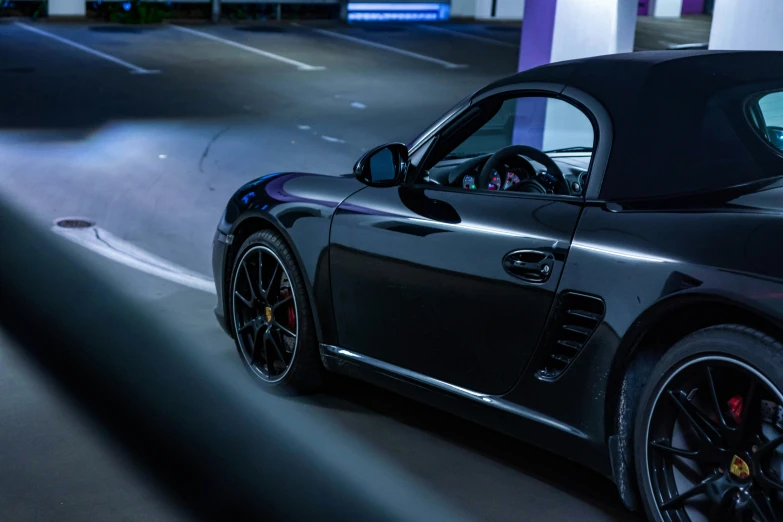 a dark sports car drives along the road