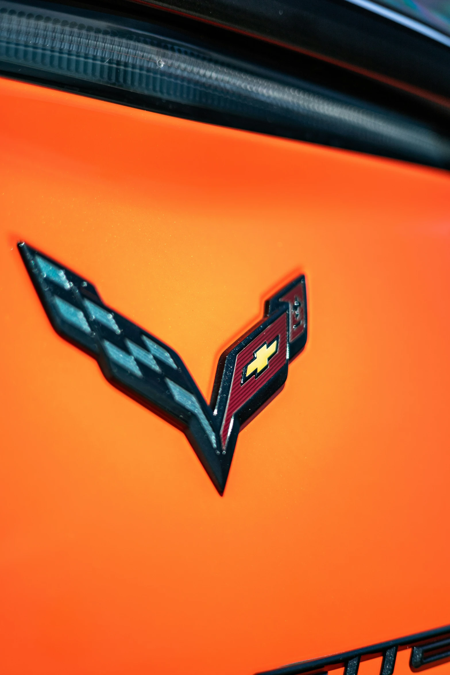 a closeup of an orange vehicle with a black hood