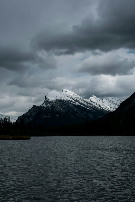 a boat is on the water below a mountain range