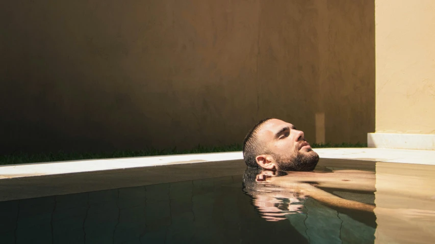 a man is taking a swim in a swimming pool