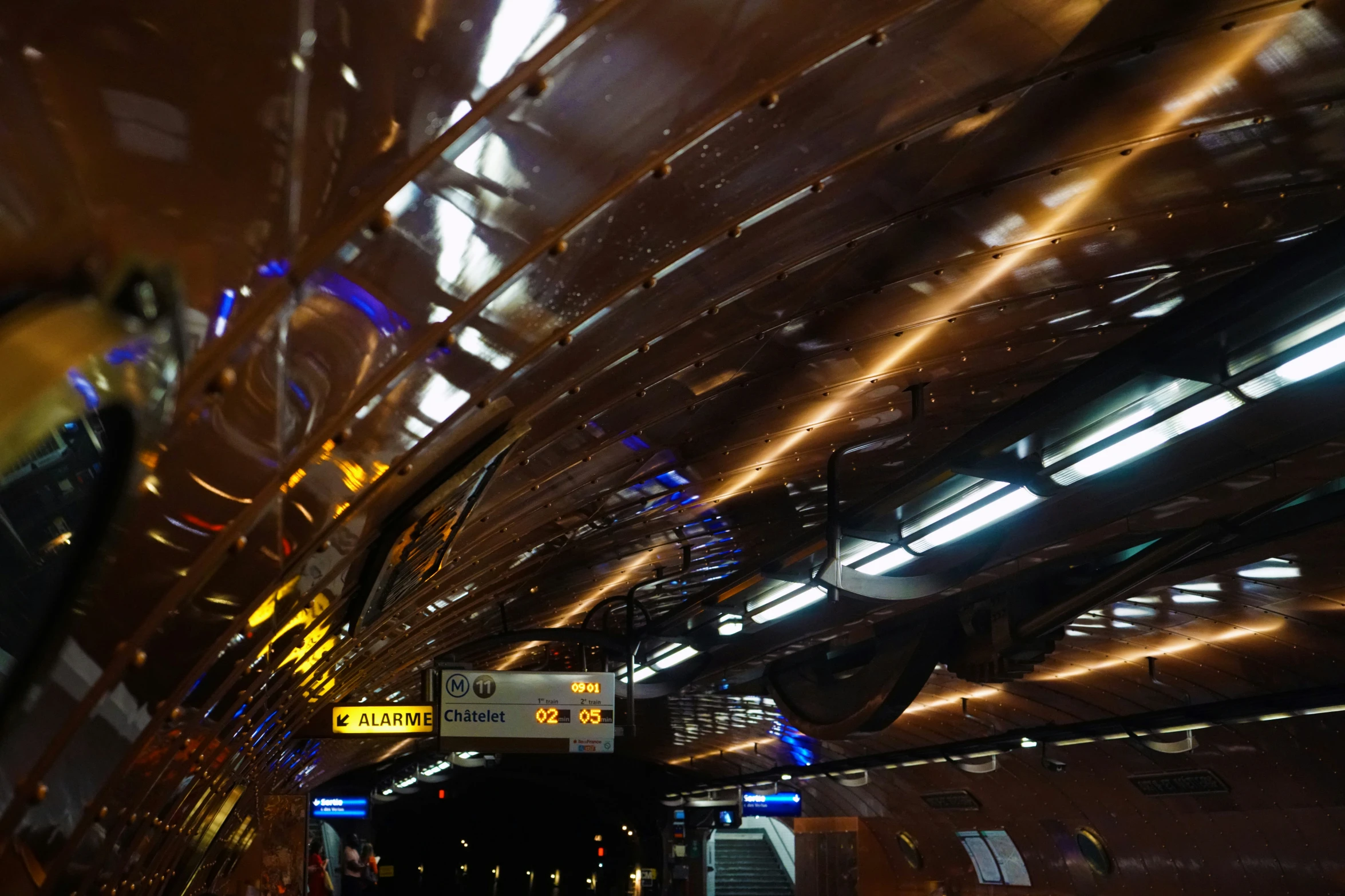 lights hang from the ceiling above a large subway car