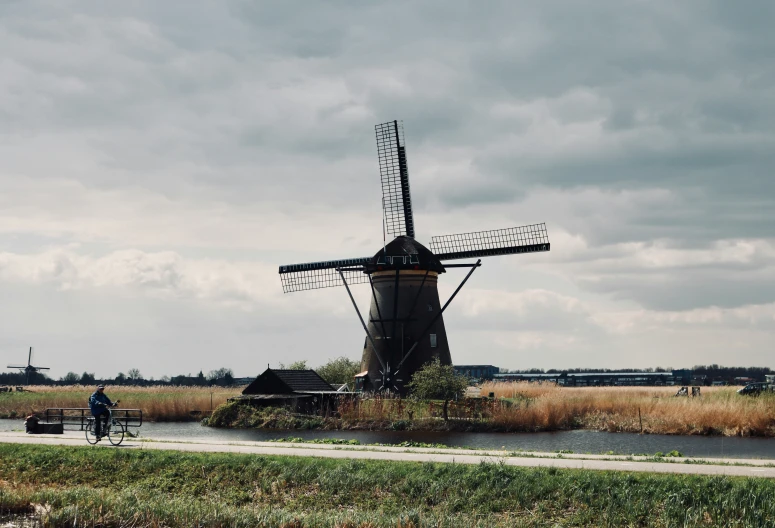 a large windmill next to a body of water