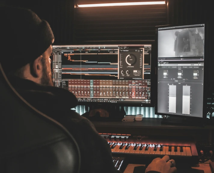 person in black sweatshirt looking at a sound mixing panel