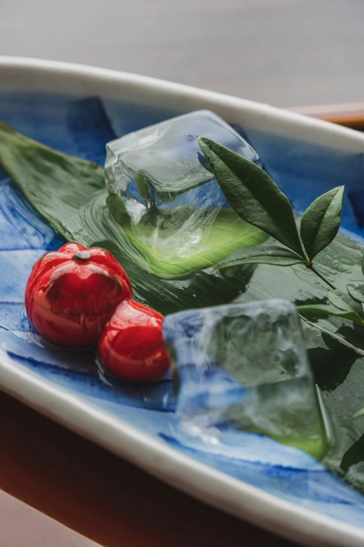 a small glass dish holding two cherries on a table