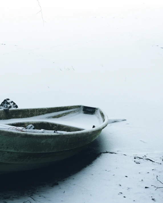 a boat on a snowy beach in the middle of winter