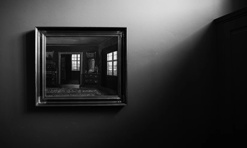 a dark room has a large mirror hanging on the wall