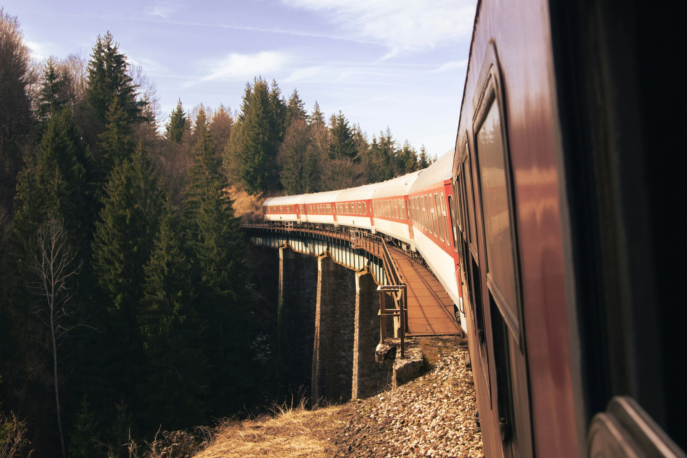 an aerial view of a train moving over the mountains