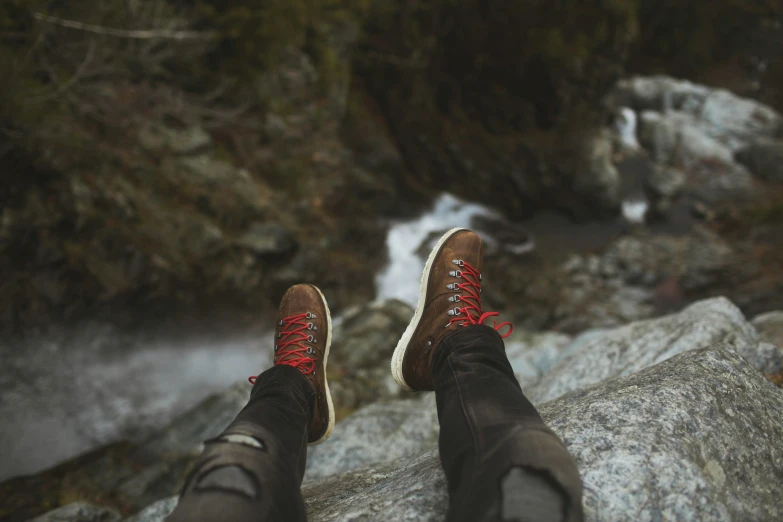 there are two feet with red shoes on a rock