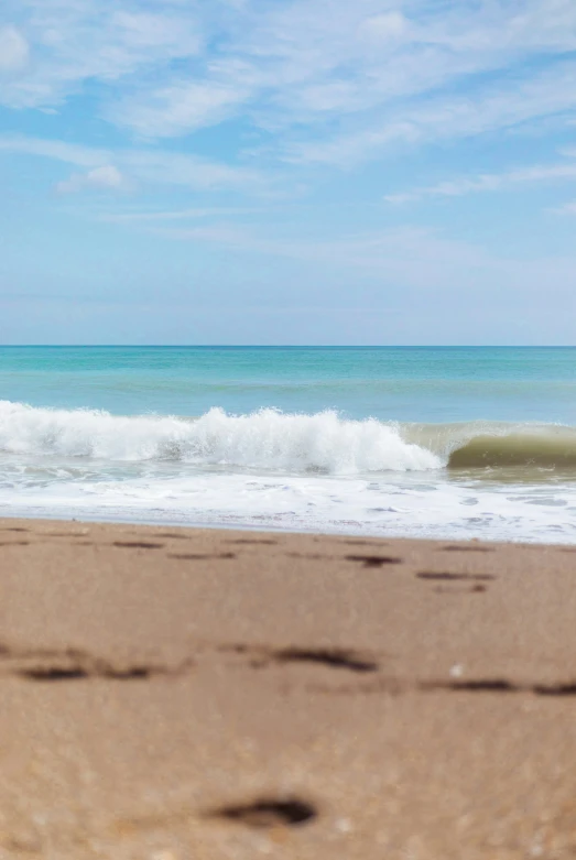 a man riding a surfboard on top of a wave covered beach