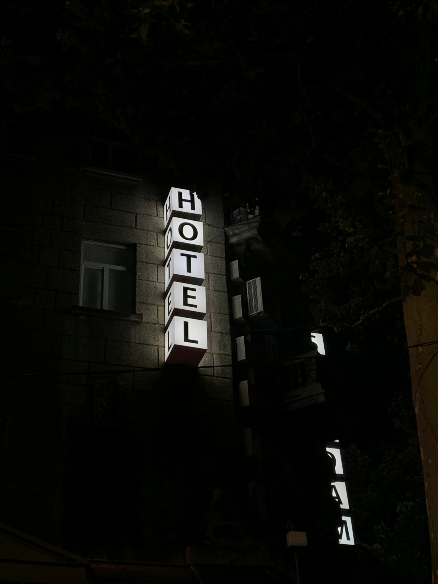 a sign and lights on a building by night