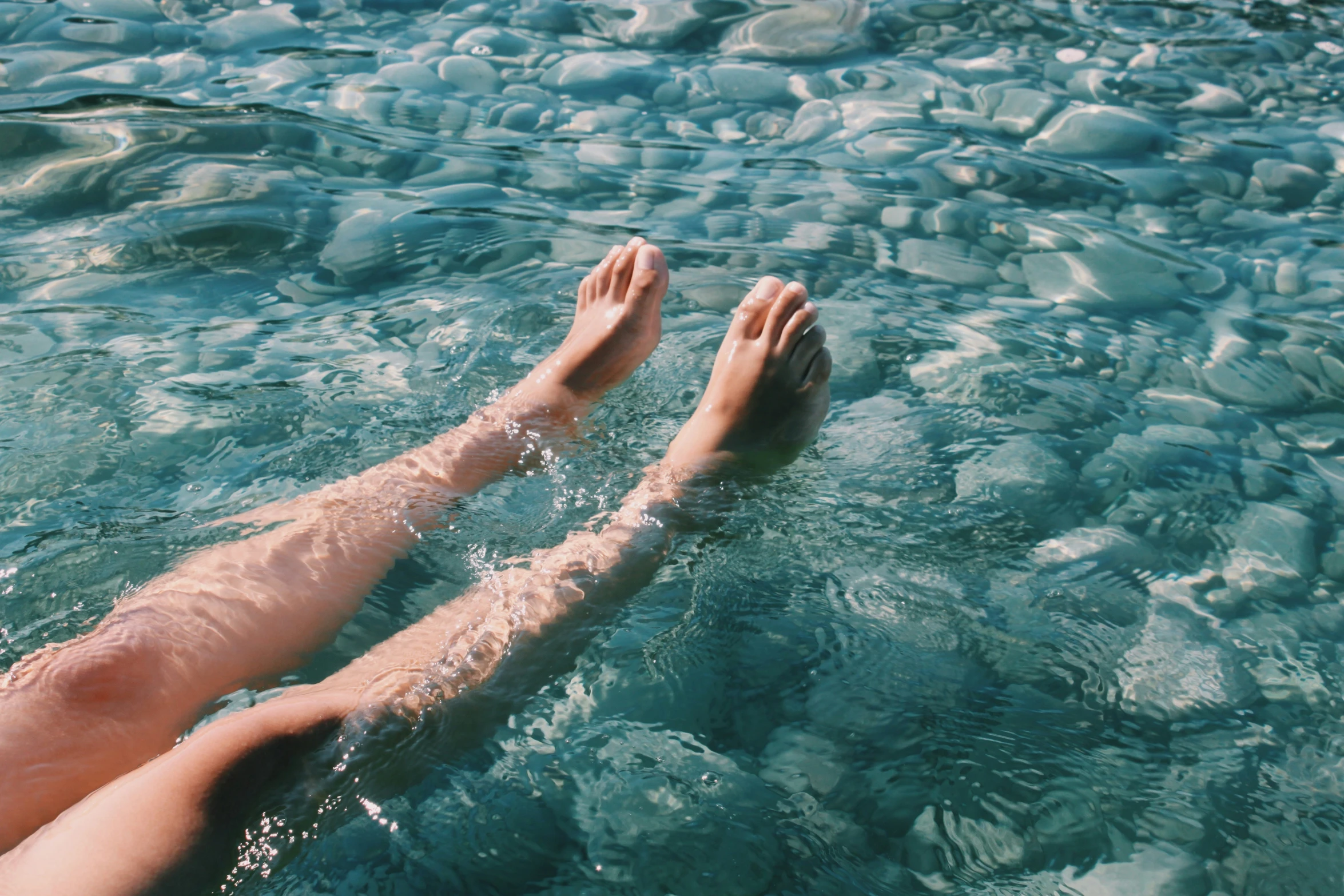 two people in the water are floating and having fun