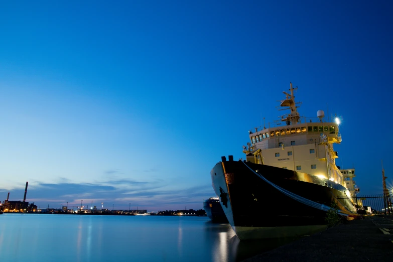 the large boat is moored to the docks at dusk